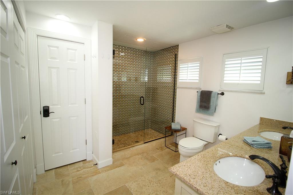 1645 Mullet Court Naples, FL 34102 - Photo 31 of 38 a bathroom with a granite countertop sink toilet and shower