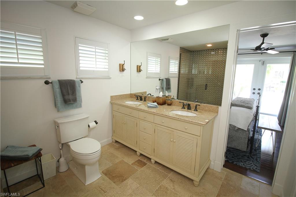 1645 Mullet Court Naples, FL 34102 - Photo 32 of 38 a bathroom with a toilet sink and mirror