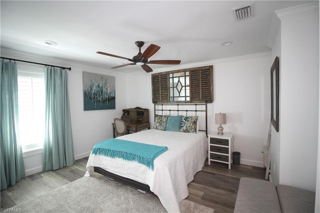 1645 Mullet Court Naples, FL 34102 - Photo 33 of 38 a bedroom with a large bed and a chandelier