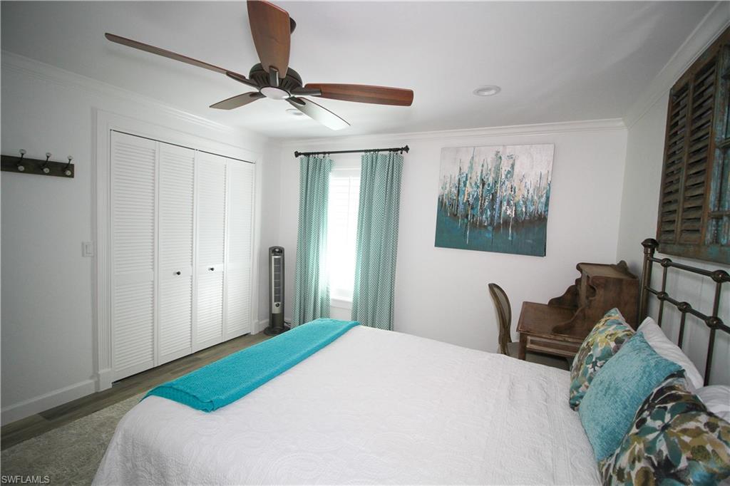 1645 Mullet Court Naples, FL 34102 - Photo 34 of 38 a bedroom with a bed and a chandelier