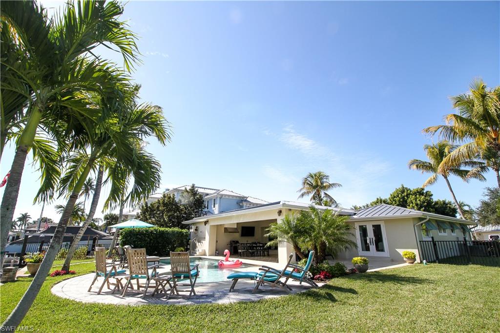 1645 Mullet Court Naples, FL 34102 - Photo 5 of 38 Rear view of house with a patio, stucco siding, french doors, and a metal roof