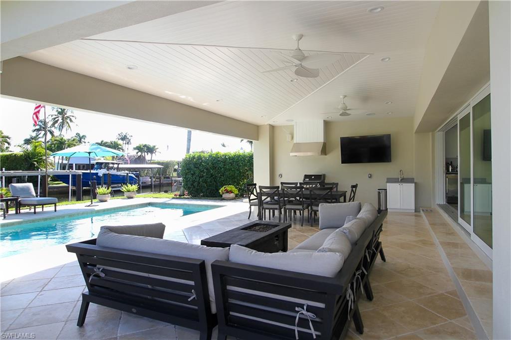 1645 Mullet Court Naples, FL 34102 - Photo 9 of 38 a view of a dining room with furniture a rug and a floor to ceiling window