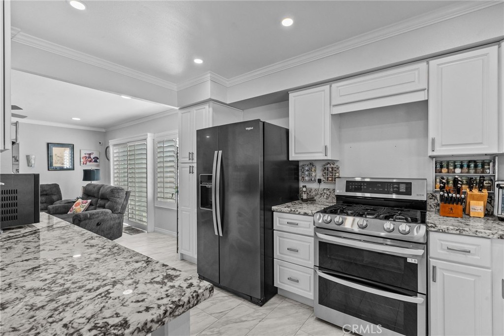 25536 Old Course Way Valencia, CA 91355 - Photo 14 of 37 a kitchen with stainless steel appliances granite countertop a stove refrigerator and cabinets
