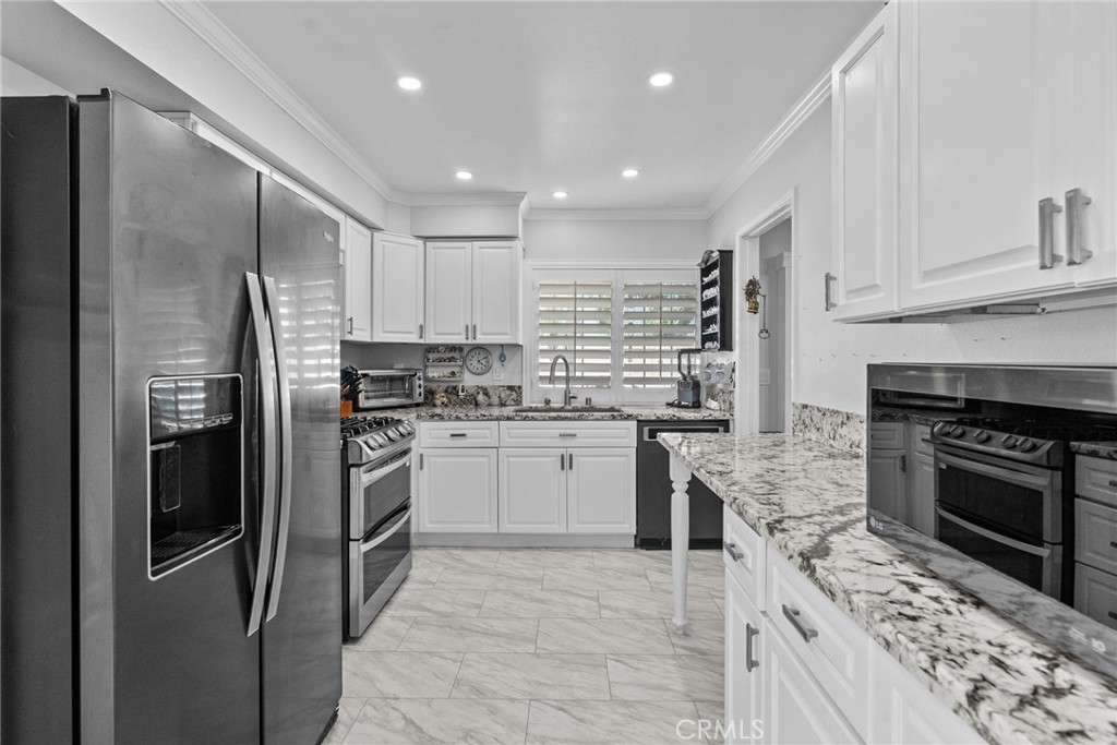 25536 Old Course Way Valencia, CA 91355 - Photo 15 of 37 a kitchen with granite countertop stainless steel appliances cabinets a sink and a counter top space
