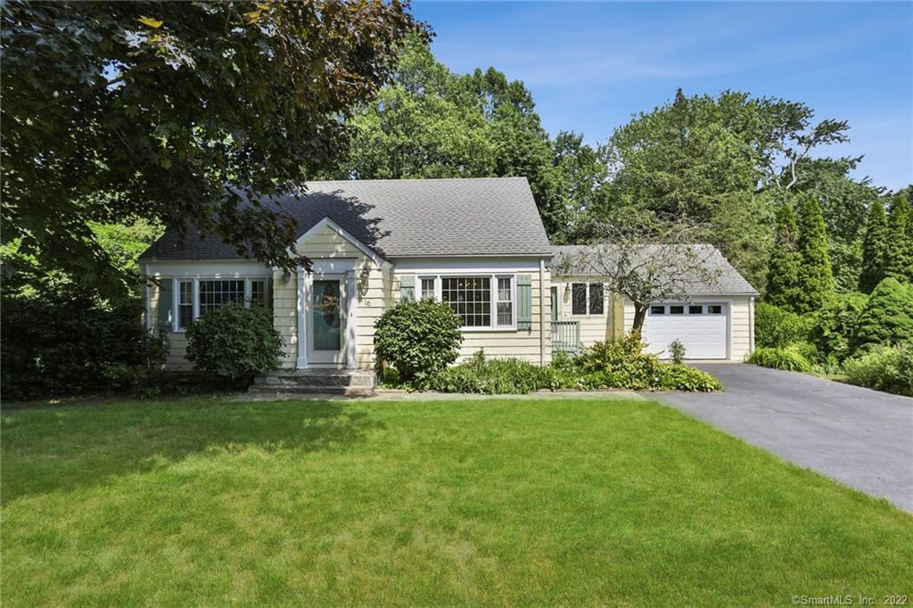 a front view of a house with a garden and yard