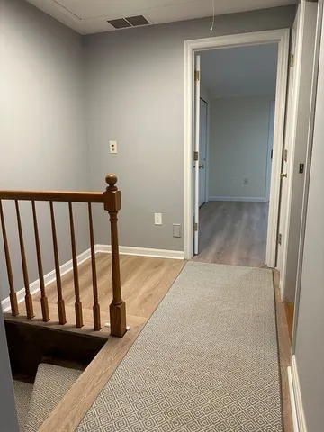 a view of a hallway with wooden floor and staircase