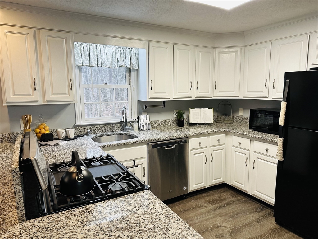 9 Averill Road, Unit B Middleton, MA 01949 - Photo 2 of 18 a kitchen with a sink stove top oven and cabinets