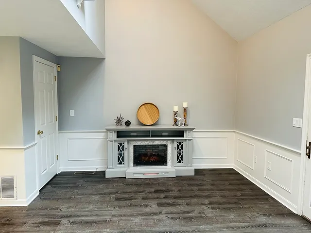 a view of empty room with wooden floor and fireplace