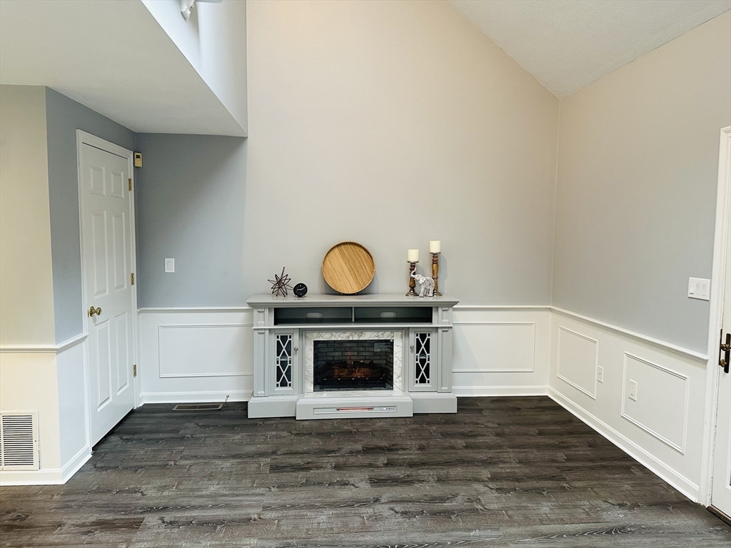9 Averill Road, Unit B Middleton, MA 01949 - Photo 4 of 18 a view of empty room with wooden floor and fireplace