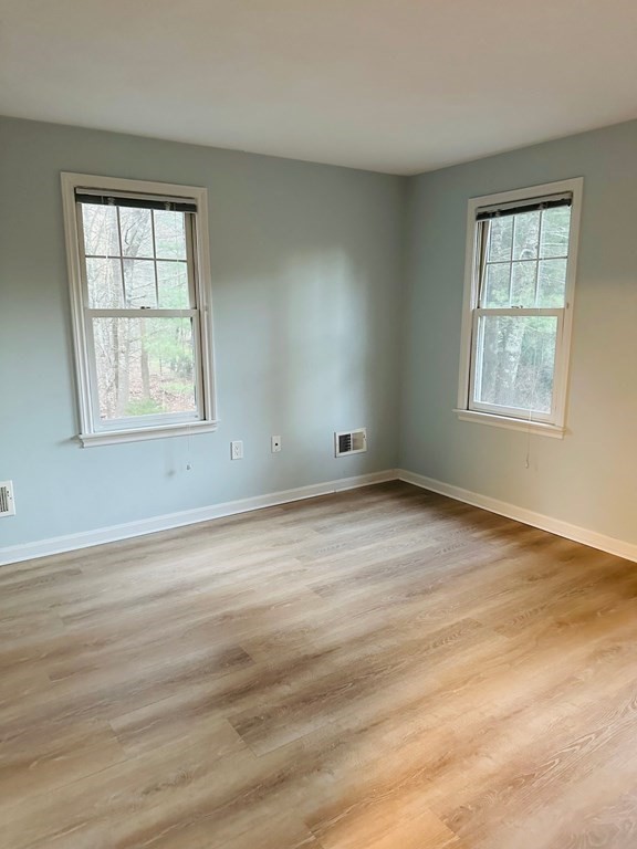 9 Averill Road, Unit B Middleton, MA 01949 - Photo 10 of 18 an empty room with wooden floor and windows