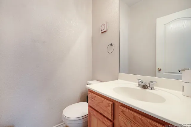 a bathroom with a granite countertop sink toilet and a mirror