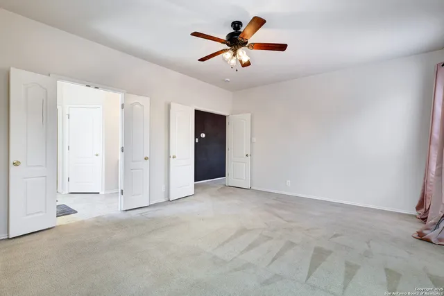 an empty room with closet and fan