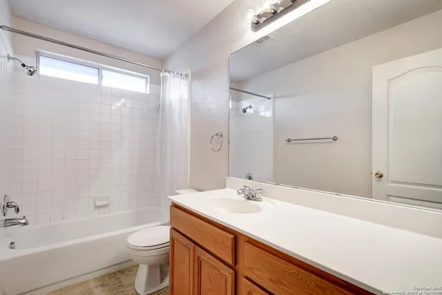 a bathroom with a sink toilet a mirror and shower