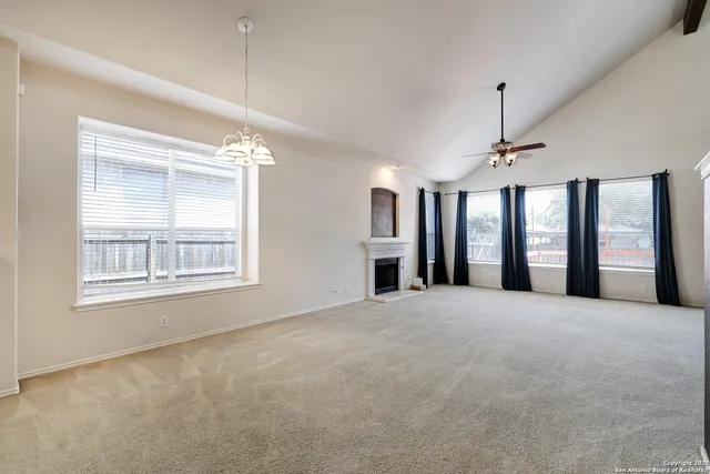 a view of an empty room with chandelier and a window