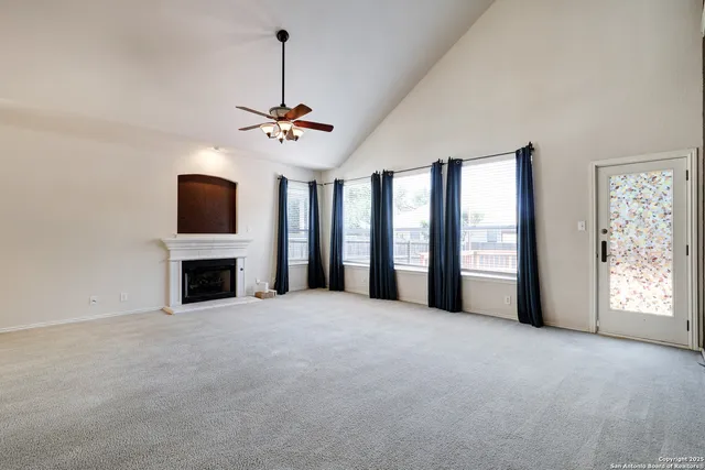 a view of an empty room with a fireplace and a window