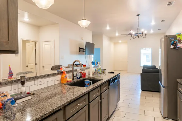 a kitchen with stainless steel appliances a dining table and chairs