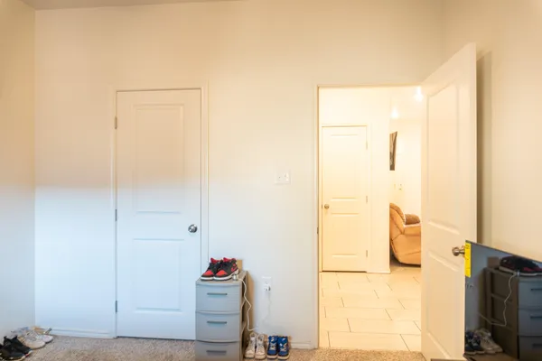a bedroom with a bed a chair and a large window