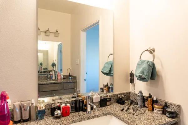 a en suite bathroom with a granite countertop sink and a mirror