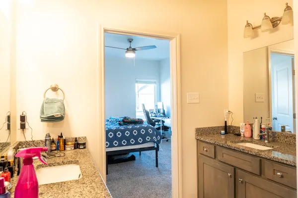 a bathroom with a granite countertop sink toilet and mirror