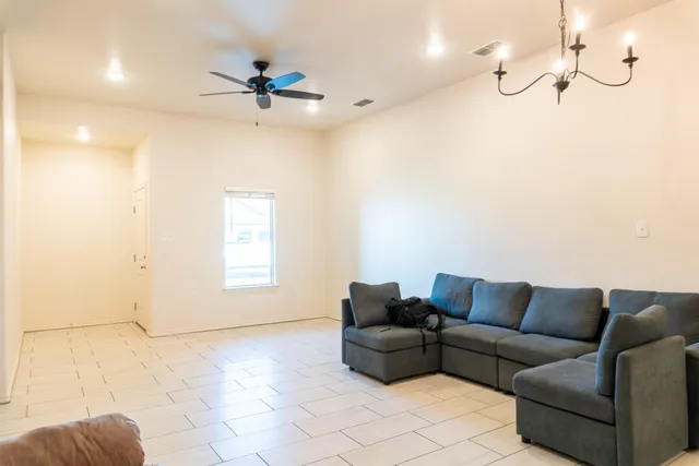 a living room with furniture and a ceiling fan