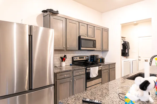 a kitchen with stainless steel appliances a refrigerator sink and microwave