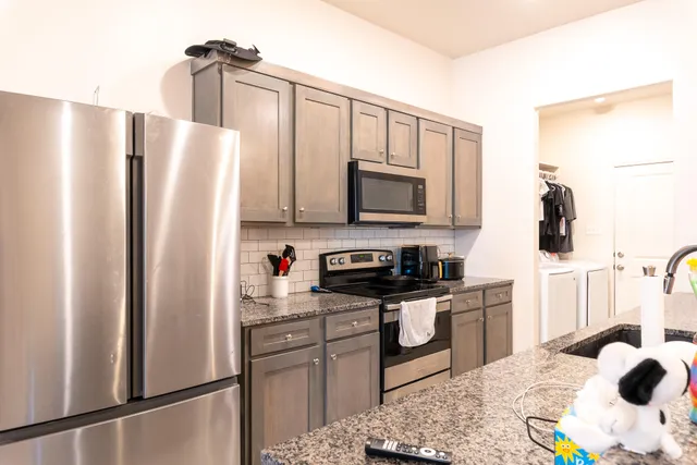 a bathroom with a granite countertop sink and a toilet