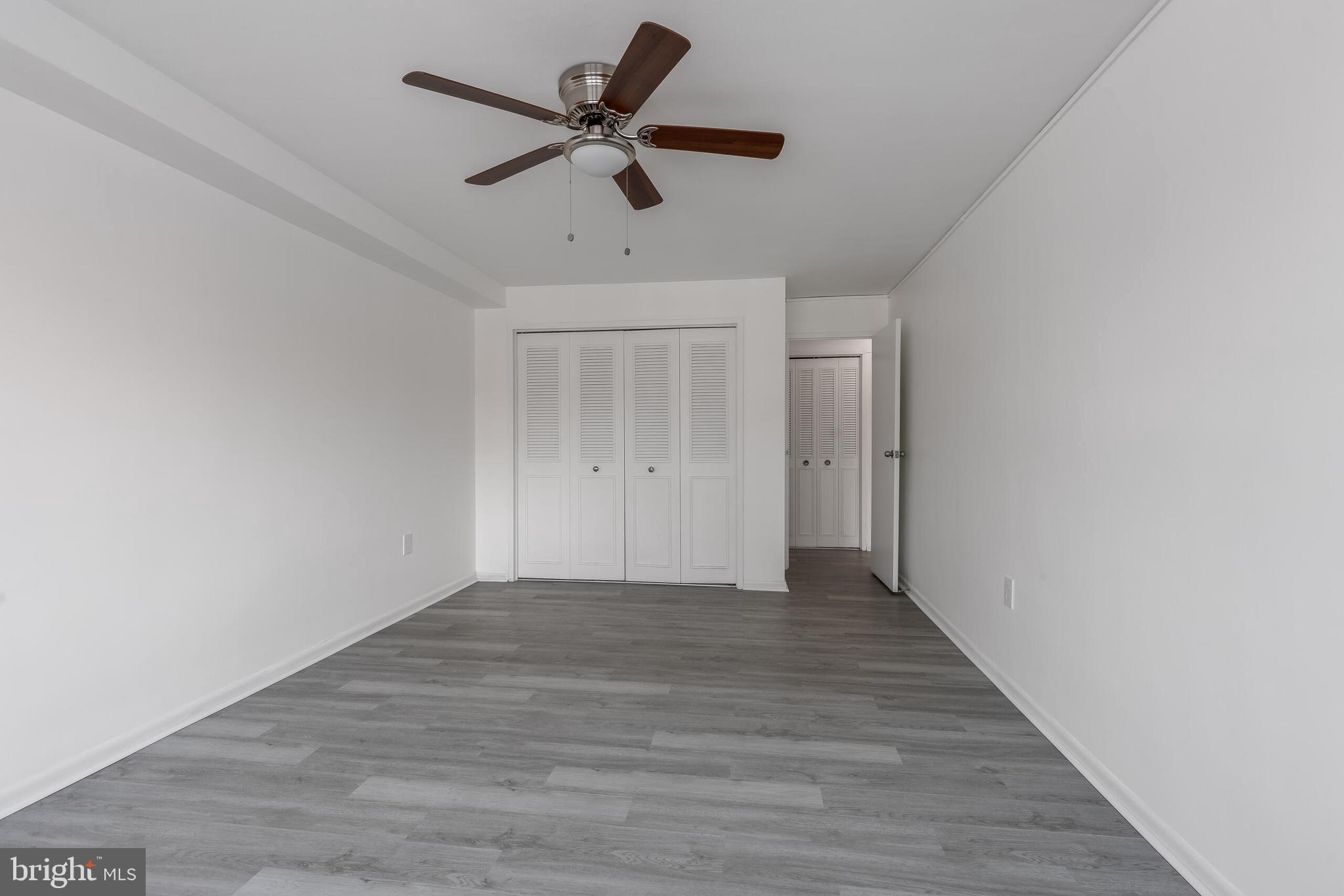 10201 Grosvenor Place, Unit 204 Rockville, MD 20852 - Photo 12 of 25 a view of a big room with wooden floor and a ceiling fan