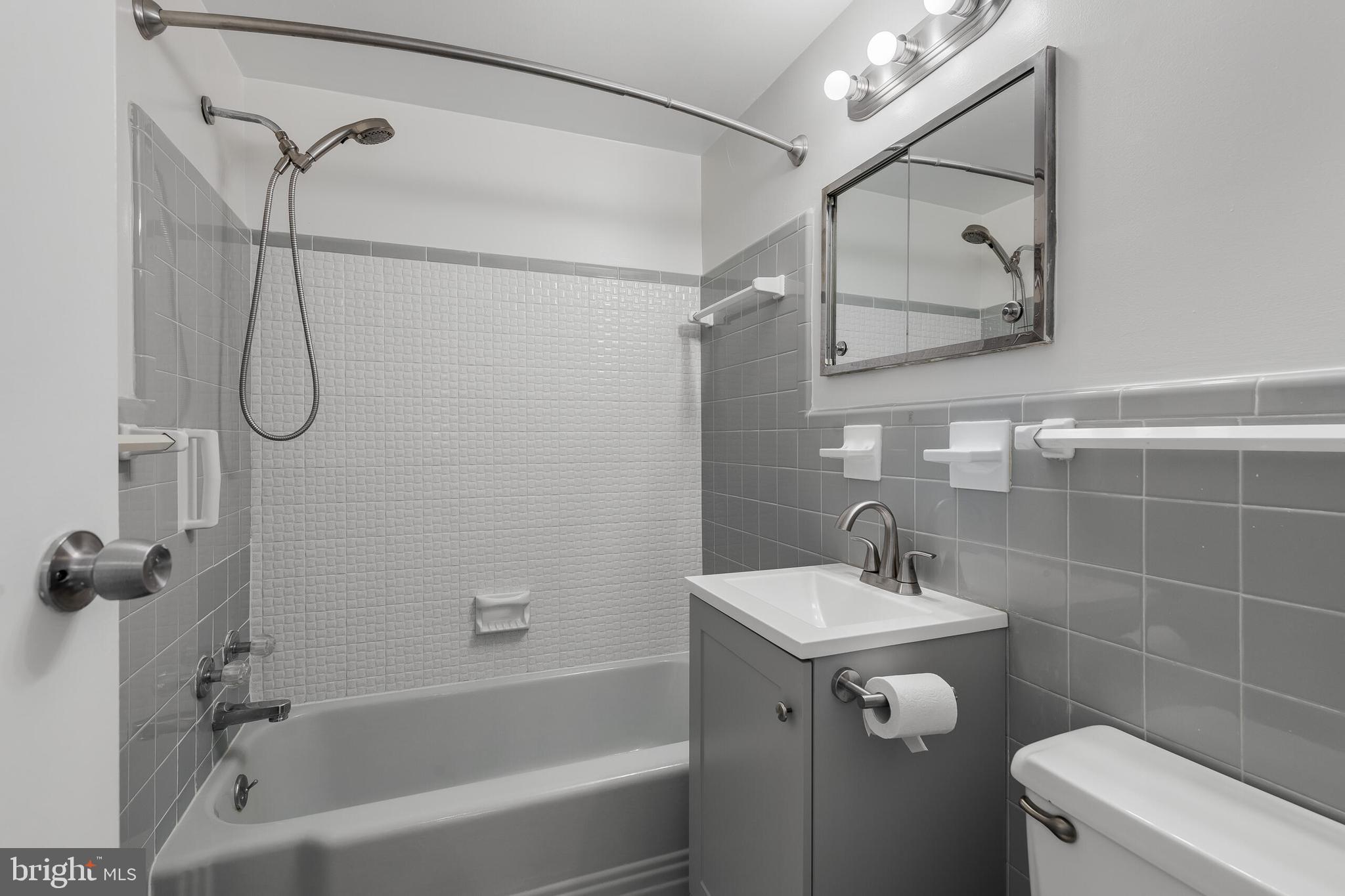 10201 Grosvenor Place, Unit 204 Rockville, MD 20852 - Photo 17 of 25 a bathroom with a sink vanity mirror and toilet