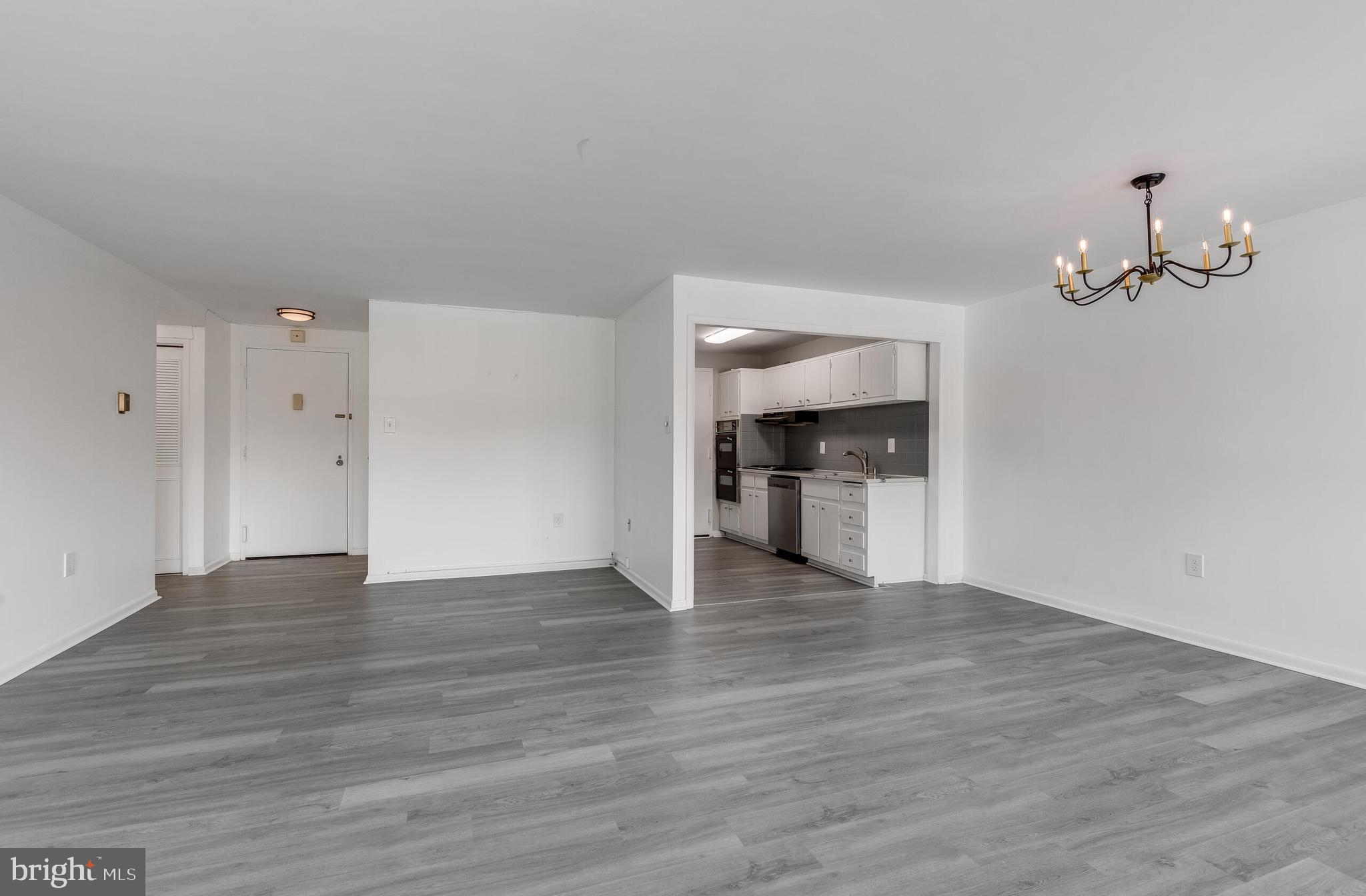 10201 Grosvenor Place, Unit 204 Rockville, MD 20852 - Photo 4 of 25 a view of an empty room with wooden floor