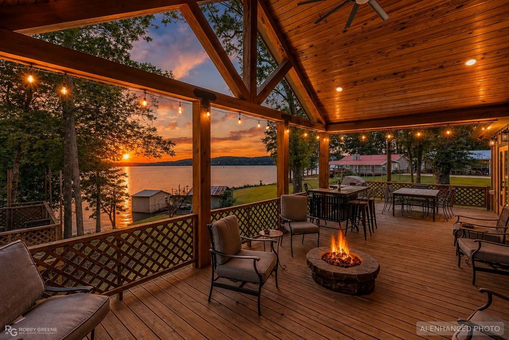 1072 Featherston Road Homer, LA 71040 - Photo 1 of 40 Expansive wood-finish deck with a stone fire pit, wood-paneled ceiling, and string lighting