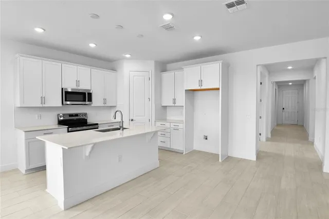 a kitchen with white cabinets and stainless steel appliances