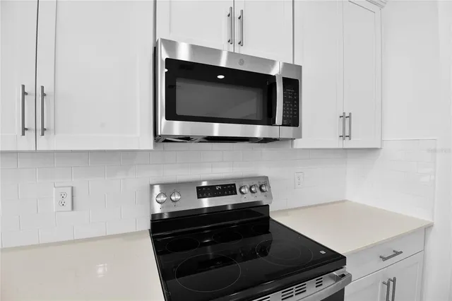 a kitchen with stainless steel appliances a stove a microwave and cabinets