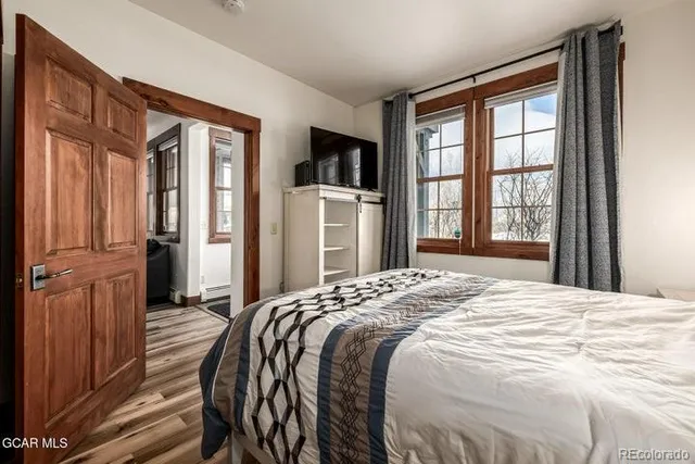 a bedroom with a bed closet and a large window