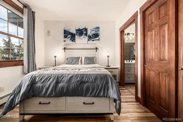 a bedroom with a bed and wooden floor