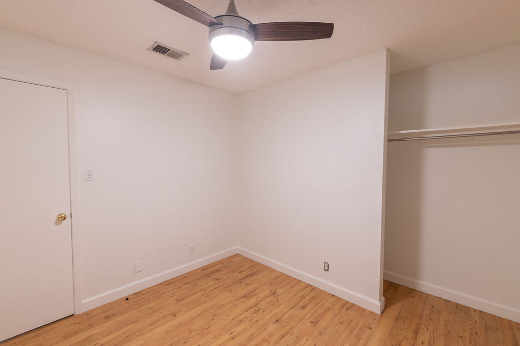5310 Presidio Road Austin, TX 78745 - Photo 23 of 34 A well-lit bedroom provides ample storage with a built-in closet and light wood-tone flooring.