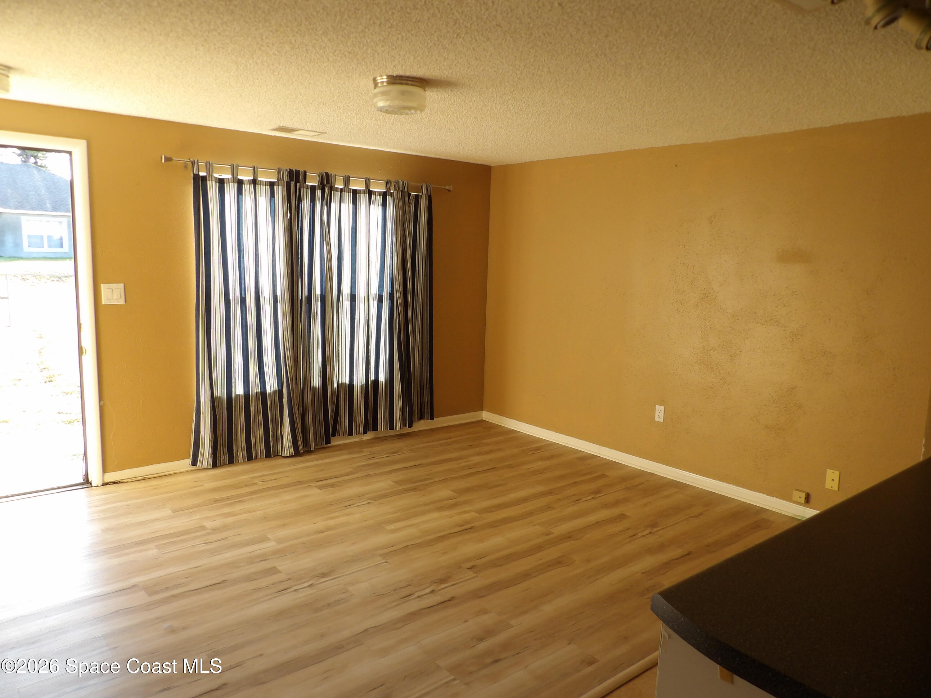 6318 Hudson Road Cocoa, FL 32927 - Photo 16 of 38 a view of an empty room with wooden floor