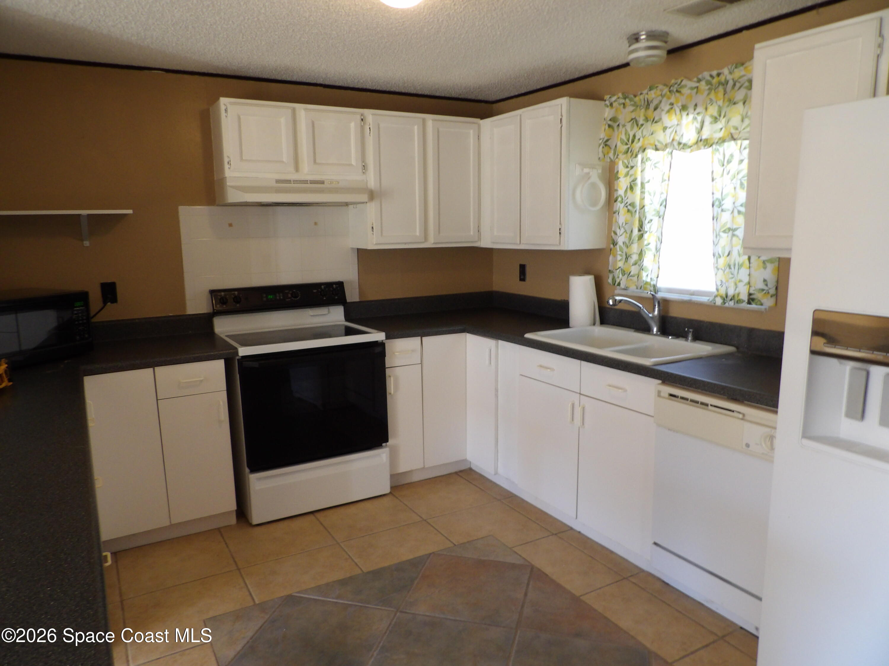 6318 Hudson Road Cocoa, FL 32927 - Photo 9 of 38 a kitchen with a sink stove and cabinets