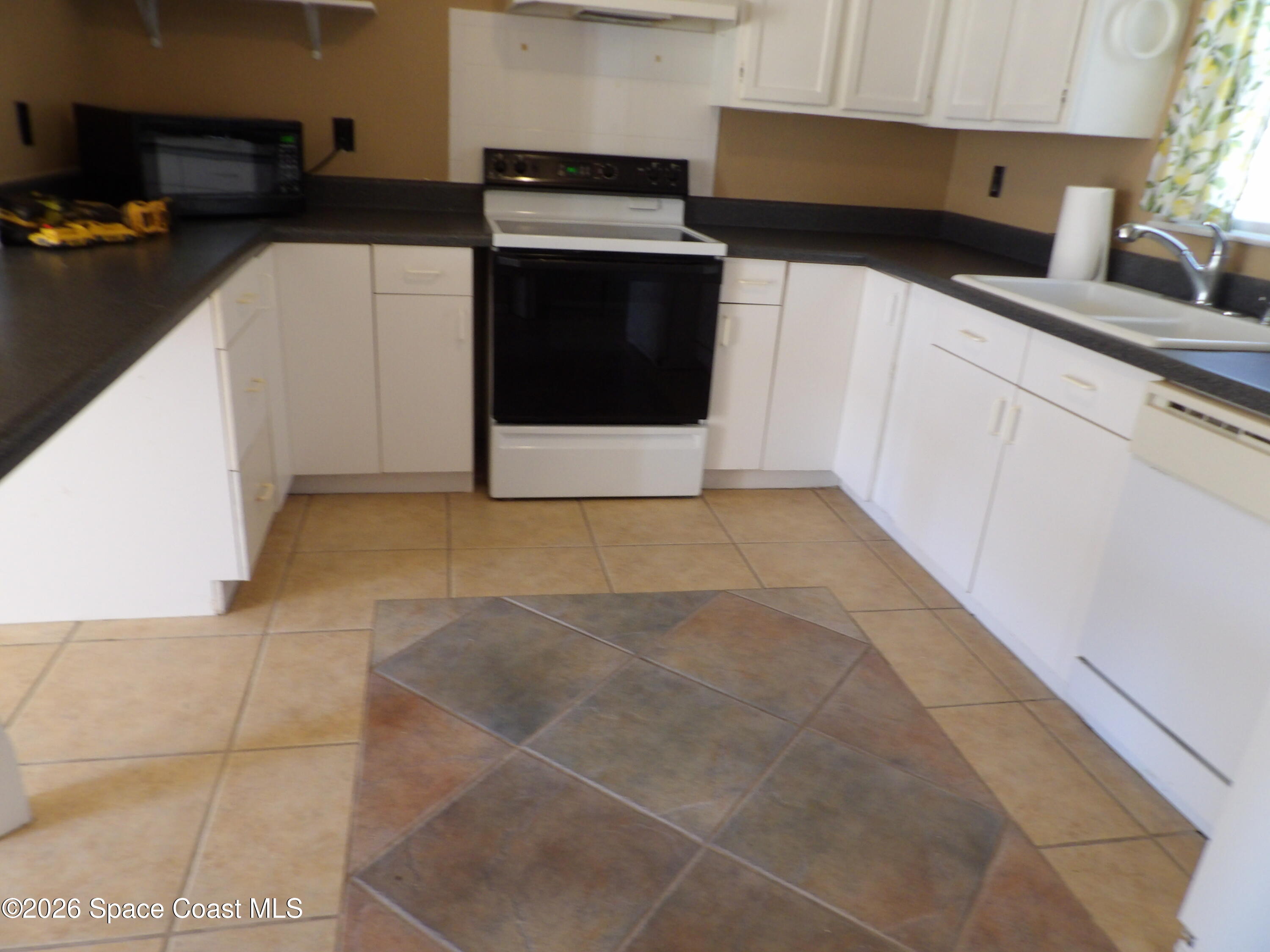 6318 Hudson Road Cocoa, FL 32927 - Photo 10 of 38 a kitchen with a sink a stove and cabinets