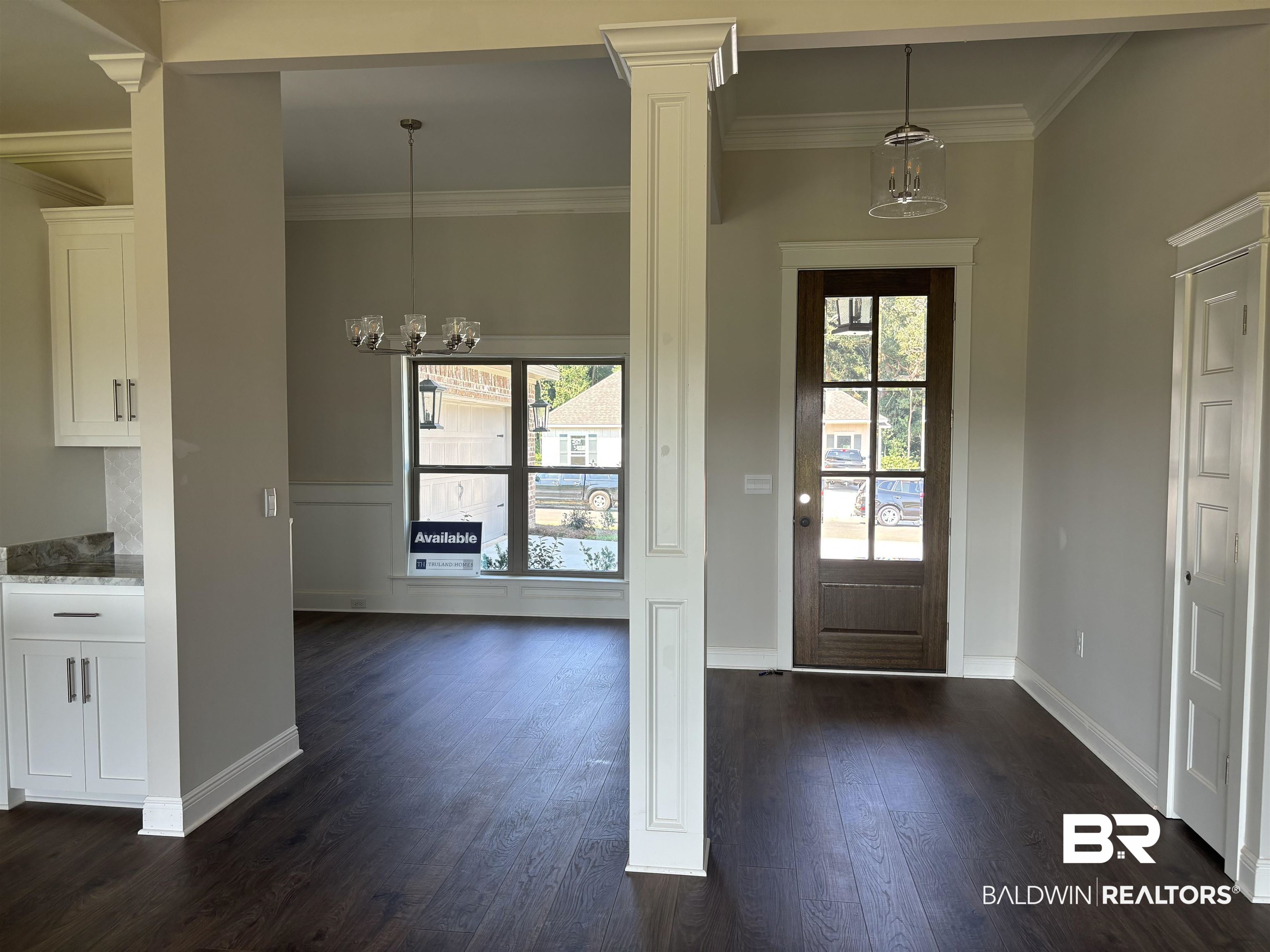 388 Garrison Boulevard Fairhope, AL 36532 - Photo 5 of 34 Entrance foyer with dark hardwood / wood-style floors, decorative columns, a chandelier, and a wealth of natural light