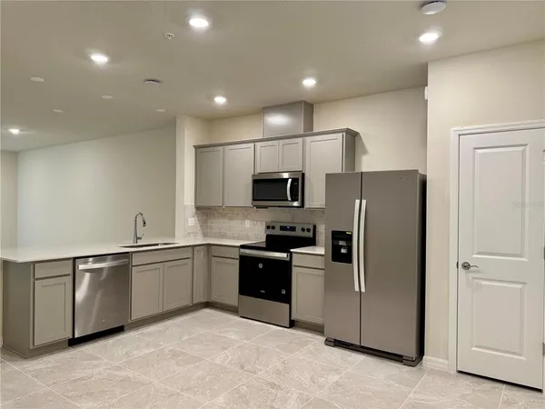 a kitchen with stainless steel appliances granite countertop a refrigerator and a sink