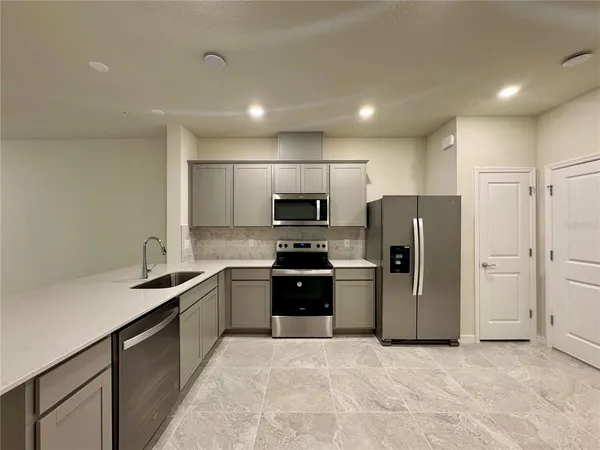 a kitchen with stainless steel appliances granite countertop a refrigerator sink and stove