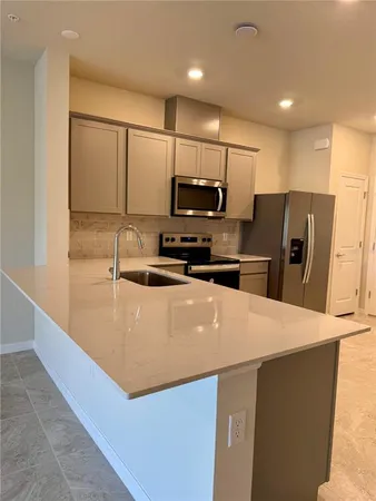 a kitchen with stainless steel appliances a refrigerator sink stove microwave and cabinets
