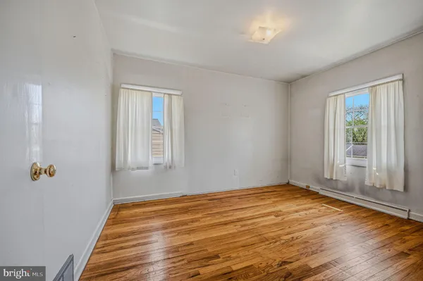 a view of a room with wooden floor and white walls
