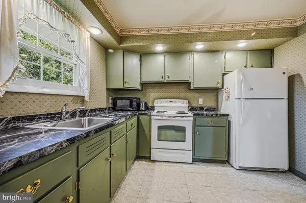 a kitchen with a white stove top oven and refrigerator