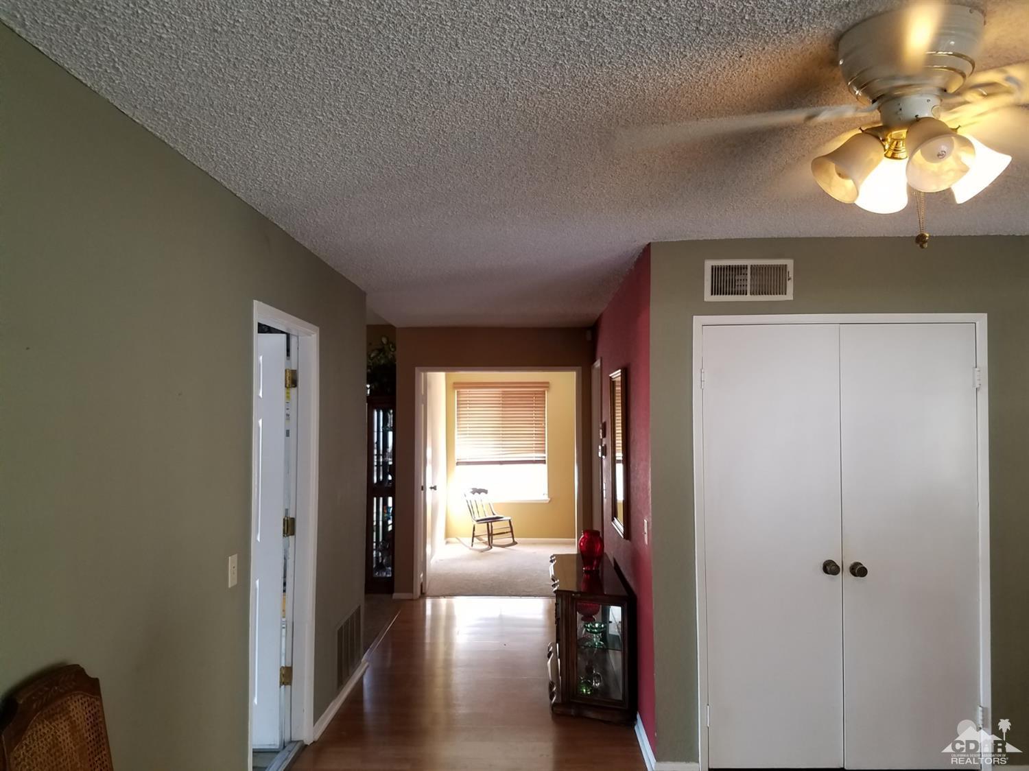 3166 Tomahawk Circle Riverside, CA 92503 - Photo 24 of 29 a view of a hallway with wooden floor and a livingroom with furniture
