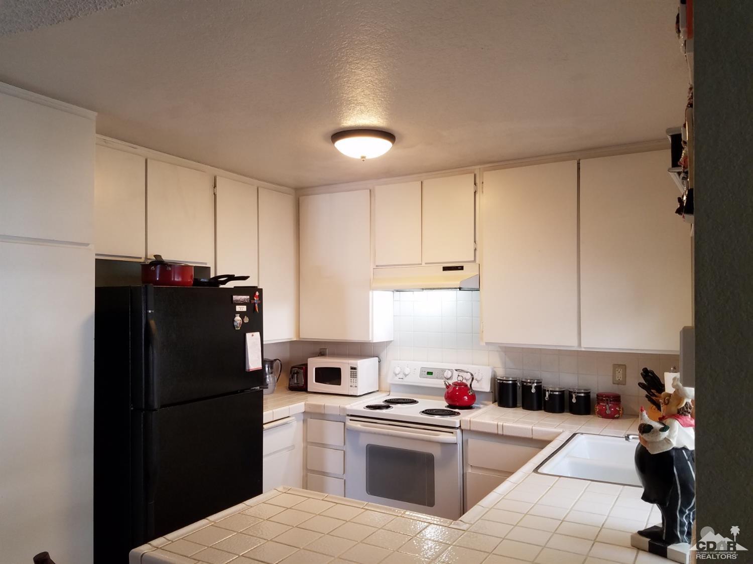 3166 Tomahawk Circle Riverside, CA 92503 - Photo 9 of 29 a kitchen with a refrigerator a stove and cabinets