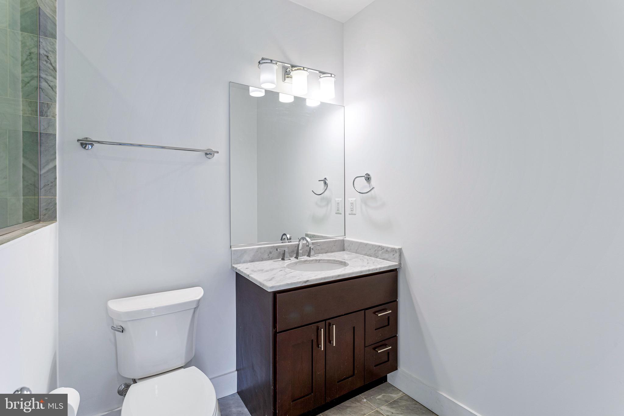 1221 Kenyon Street Northwest, Unit 2 Washington, DC 20010 - Photo 15 of 26 a bathroom with a toilet sink and mirror