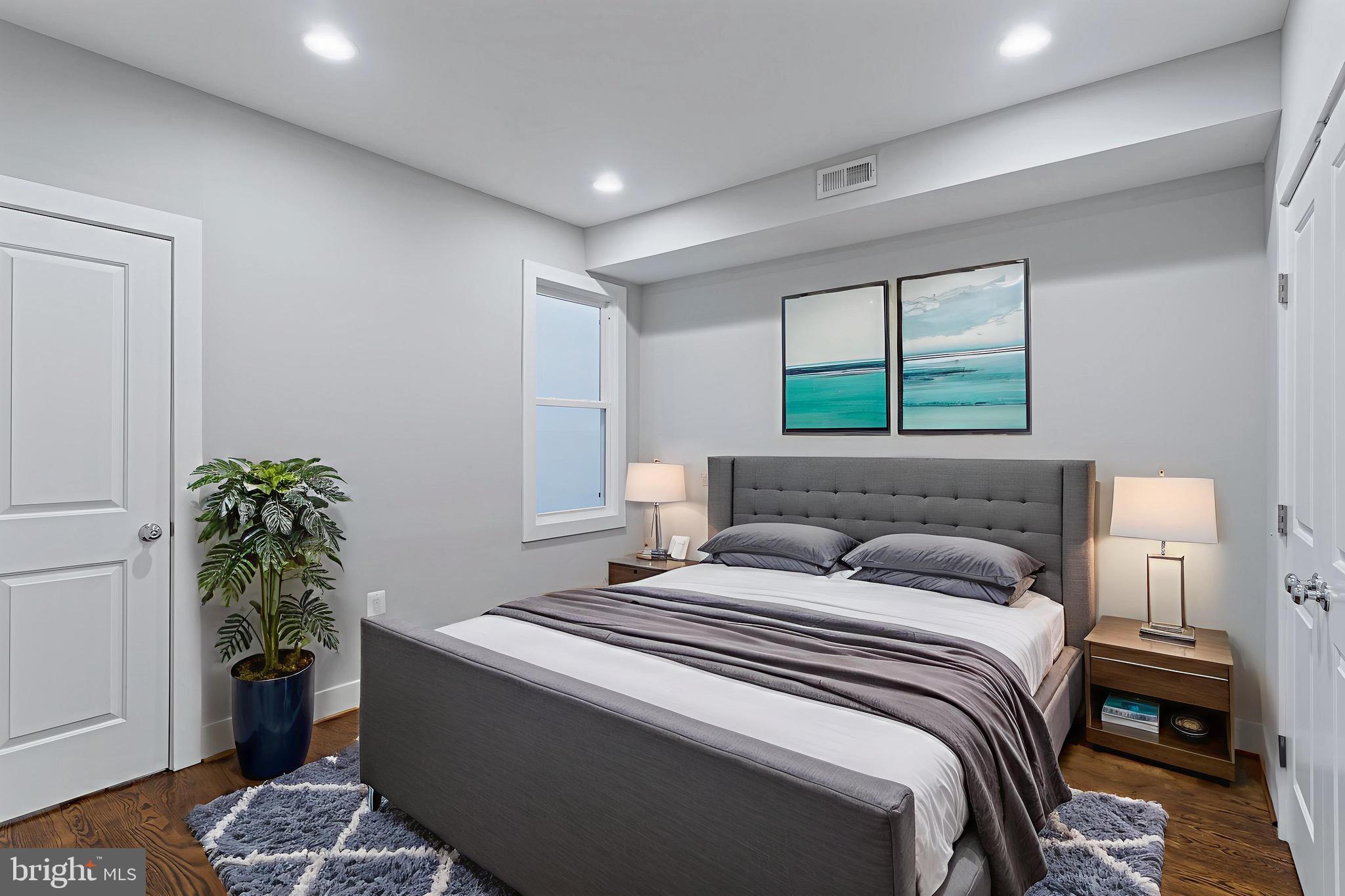 1221 Kenyon Street Northwest, Unit 2 Washington, DC 20010 - Photo 16 of 26 a bedroom with a large bed and a potted plant