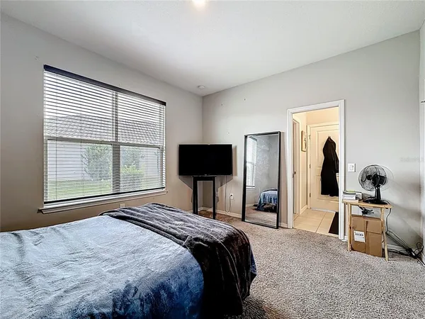 a bedroom with two bed and a desk