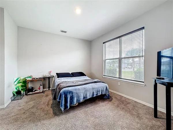 a bedroom with a bed and dresser with mirror